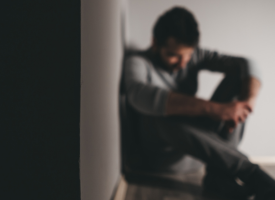 Person sitting against wall