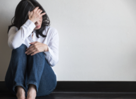 Woman sitting against wall